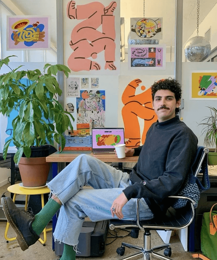 Designer sitting in an art-filled studio