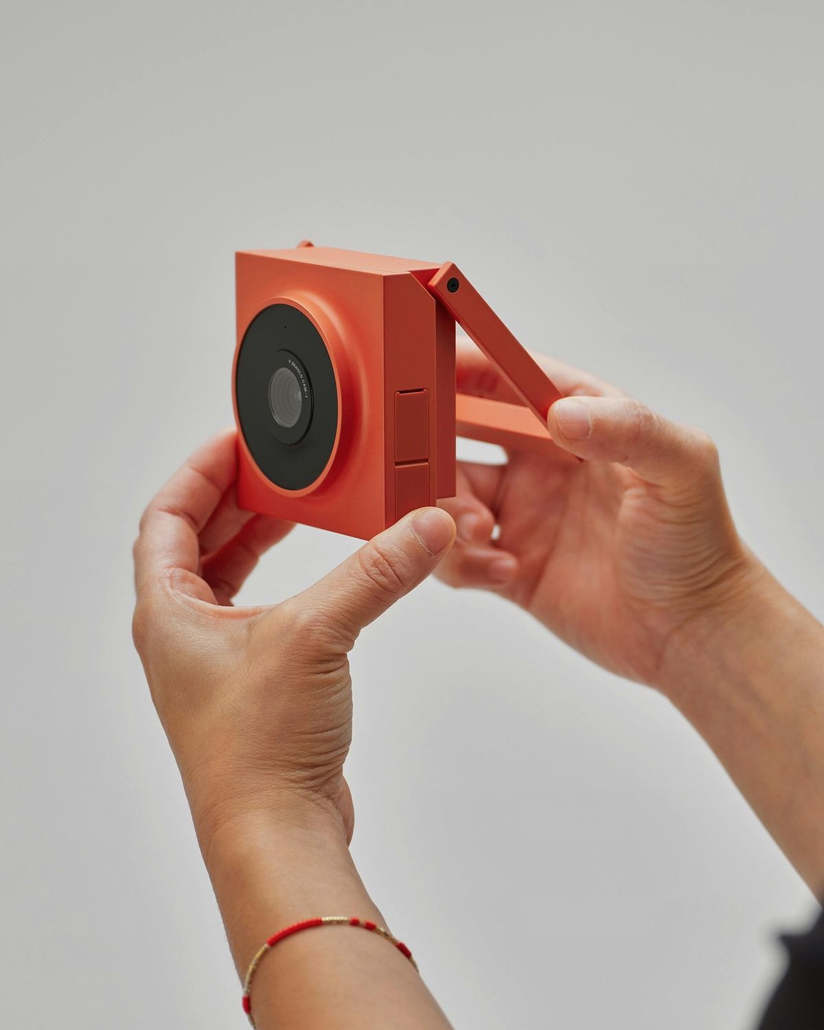 Hands unfolding the handle on a portable camera