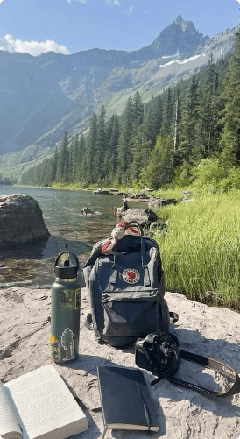 Backpack beside a mountain lake with hiking gear