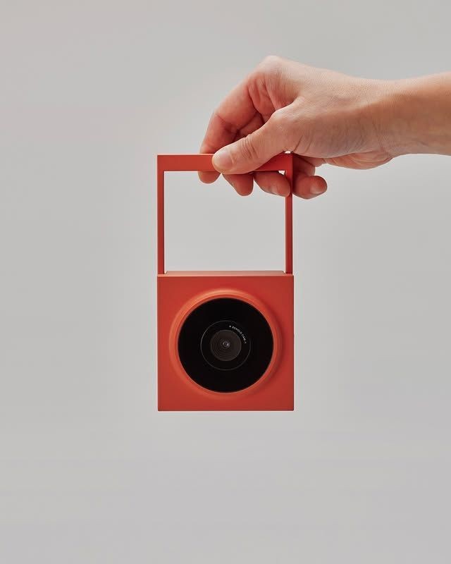 Hand holding a portable camera with a folding handle